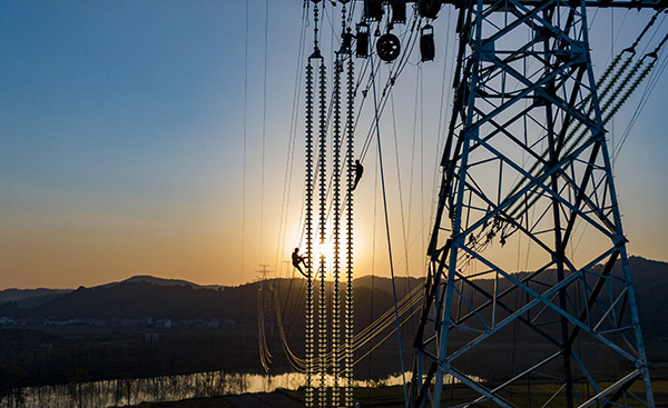 2020年11月10日，湖南邵阳，工人爬上80多米高的高塔架设电网。人民视觉 资料图